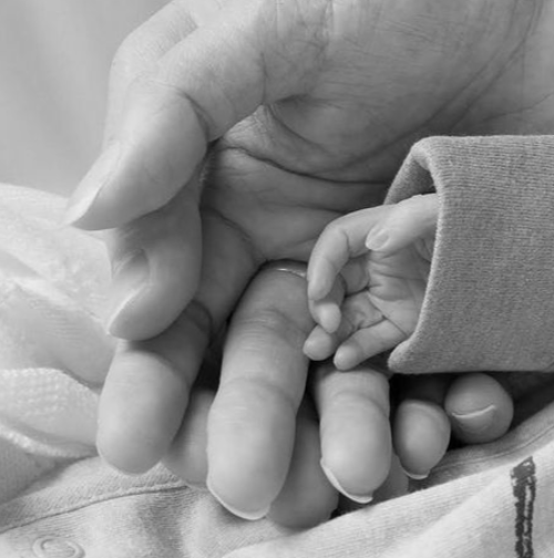 Femme tenant délicatement une fleur blanche en mémoire de son bébé perdu lors d'une fausse couche